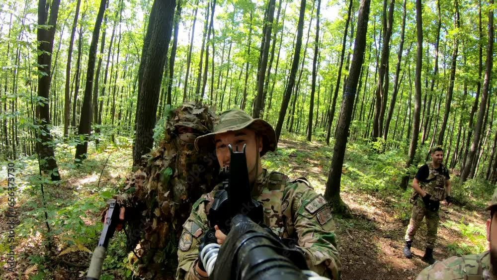 POV Close-up group of soldiers aiming with gun while moving through forest during military action. Squad of equipped fighters in camouflage uniform in forest. POV Close-up group of soldiers aiming with gun while moving through forest during military action. Squad of equipped fighters in camouflage uniform in forest.