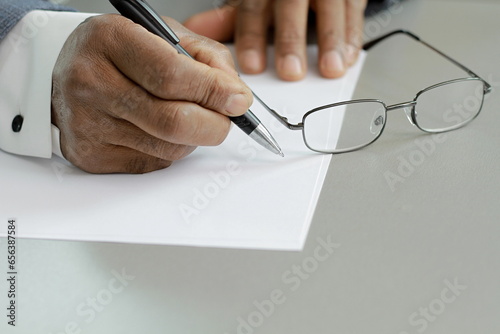 business man writing with pen on a office table with grey background with people stock image stock photo