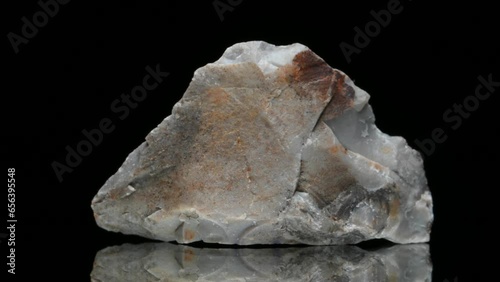Flint - sedimentary cryptocrystalline form of quartz (c5cm across) sample rotating slowly against a black background. photo