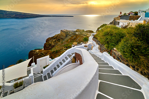 Winding steps down the hill of Santorini island, Greece, at sunset. 
