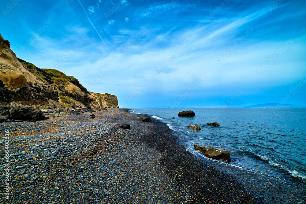 Dramatic landscape of black volcanic beach and blue sky and clouds