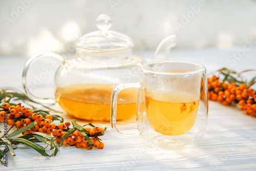 vibrant hues of sea buckthorn tea captured in a transparent teapot
