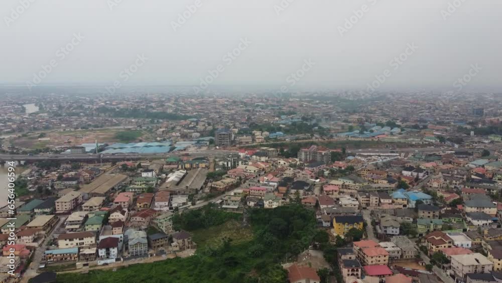 Aerial view community in Lagos Nigeria on a hazy day with drone moving from busildings to reveal a highway with cars and trucks moving speedily. Aerial view community in Lagos Nigeria on a hazy day with drone moving from busildings to reveal a highway with cars and trucks moving speedily.