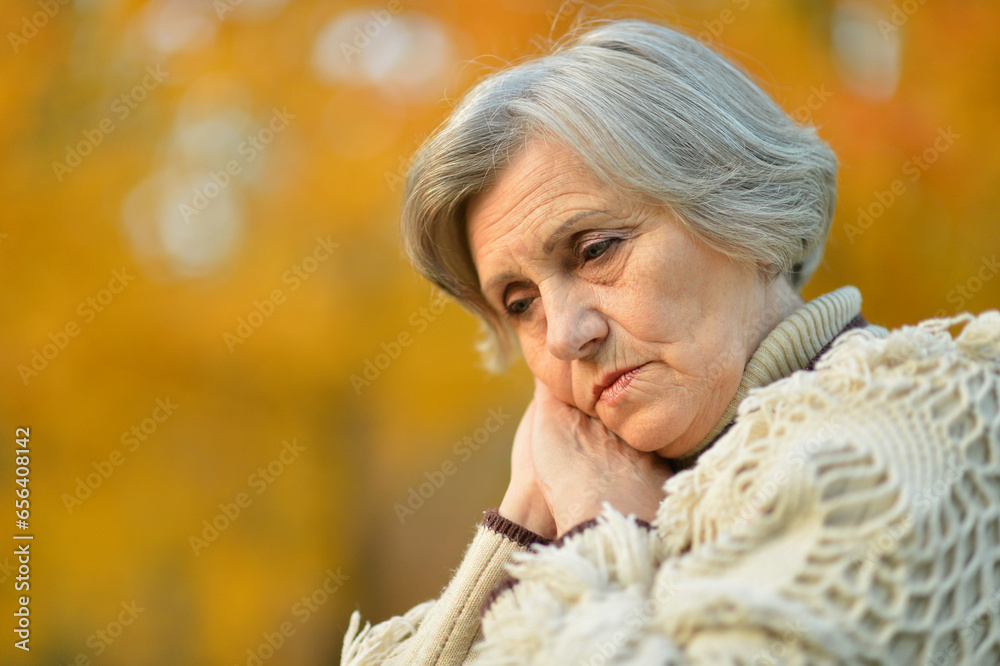 Sad senior woman with headache in park Sad senior woman with headache in park