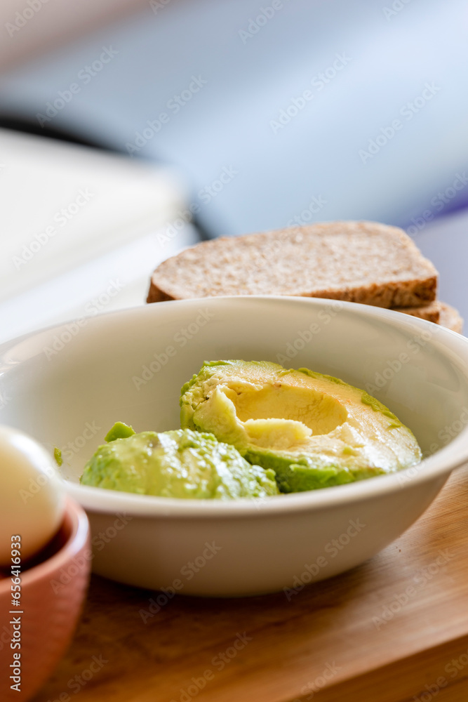 Avocado Peeling in a Bowl on Wooden Board Avocado Peeling in a Bowl on Wooden Board