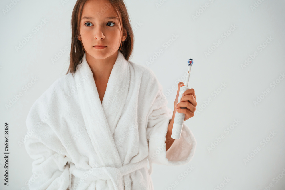 Toothbrush in hand. Conception of beauty and self care. Young girl is in the studio Toothbrush in hand. Conception of beauty and self care. Young girl is in the studio