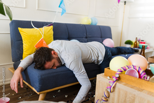 Canvas Print Unconscious man after drinking a lot of alcohol sleeping on the sofa