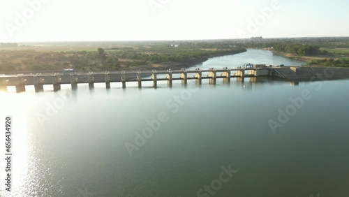 High aerial view: cross over dam wall from reservoir to see flowing overflow water photo