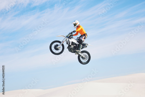 Motorcycle, jump and man in the air with blue sky, mock up and stunt in sports with fearless person in danger with freedom. Motorbike, jumping and athlete training for challenge or competition