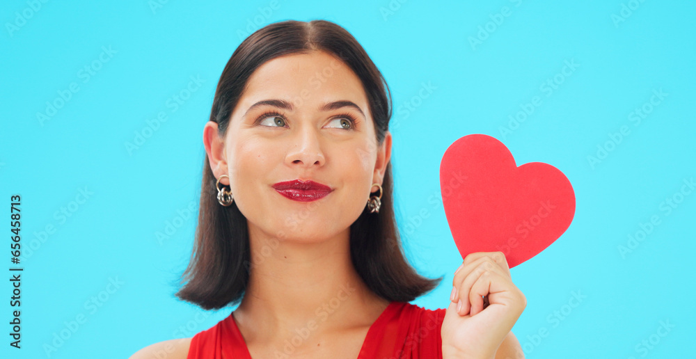 Thinking, happy and woman with paper heart in studio isolated on a blue background mockup. Idea, romance and model with love sign for anniversary, emoji and smile for valentines day gift or present Thinking, happy and woman with paper heart in studio isolated on a blue background mockup. Idea, romance and model with love sign for anniversary, emoji and smile for valentines day gift or present