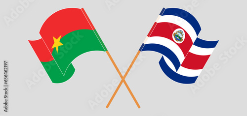 Crossed and waving flags of Burkina Faso and Costa Rica