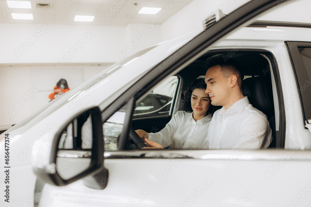 Naklejka premium Young couple holding the keys of a new car