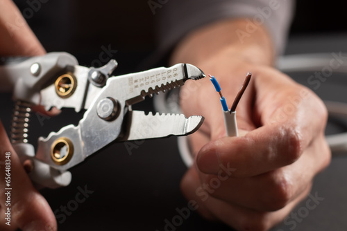 Cuadro en lienzo The use of the stripper cutter tool to strip the end of the electrical wire