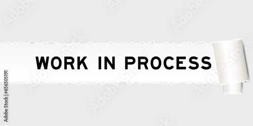 Ripped gray paper background that have word work in process under torn part