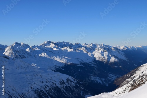Beautiful view of the snowy Ötztal Valley, Tyrol, Austria during peak ski season in the winter. Shot from Hochgurgl ski resort on a beautiful sunny day.