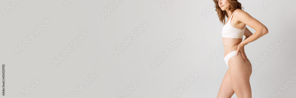 Cropped image of slim female body. Model posing in underwear against grey studio background. Anti-cellulite care. Concept of body and skin care, fitness, natural beauty, health, wellness. - obrazy, fototapety, plakaty 
