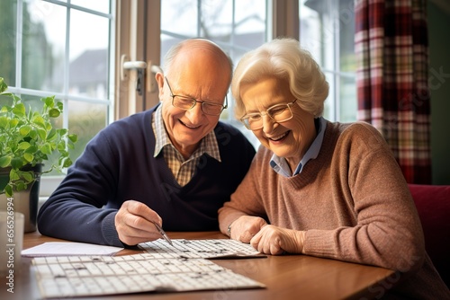 An elderly couple solves a  crossword together at home photo