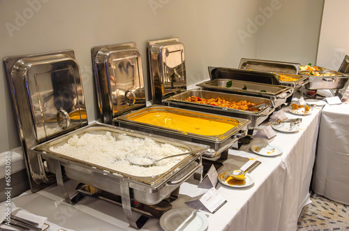 Hot food at a self service buffet kept warm in chafing dishes at a party in a hotel