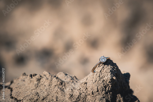 diamond engagement ring resting on top of a rock