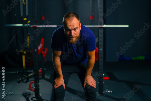 portrait of a tired athlete in the gym after training a man wipes sweat from his forehead with his hand