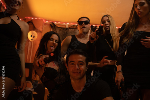 European Halloween party in a friends apartment- -Images of Young adults celebrating Halloween. photo