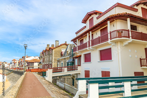 Red and white basque houses on the seaside of the Promenade Jacques Thibaud in Saint-Jean-de-Luz, France photo