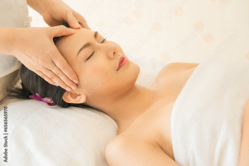 Close-up facial massage. Spa skin and body care. Beautiful young Asian woman getting spa massage treatment at beauty spa salon. Facial beauty treatment. Beauty photo concept, skin care, facial massage Close-up facial massage. Spa skin and body care. Beautiful young Asian woman getting spa massage treatment at beauty spa salon. Facial beauty treatment. Beauty photo concept, skin care, facial massage