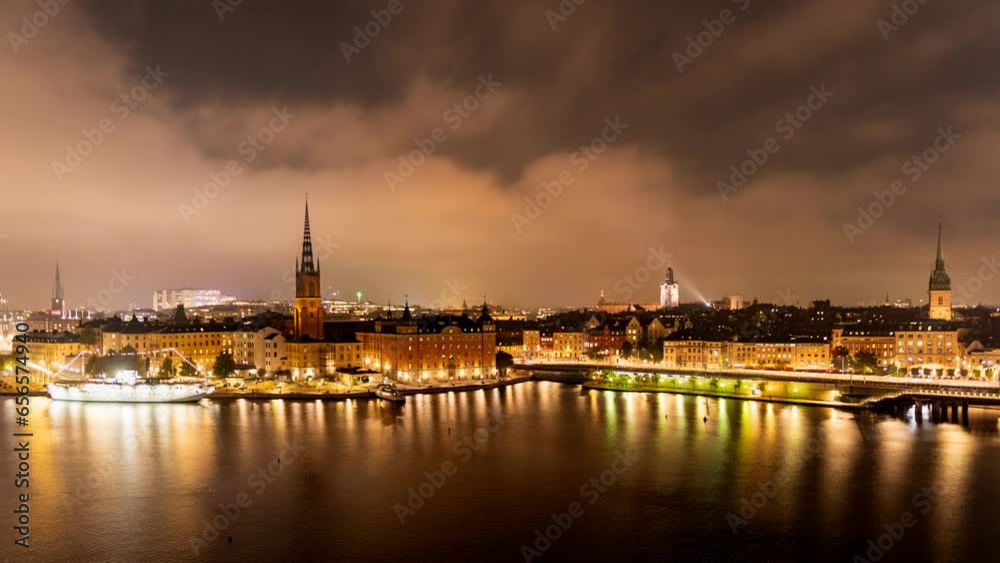 Time lapse Stockholm Sweden: city lights, night view of Stadsholmen district (Gamla Stan) and Riddarholmen district, buildings reflected in the water. Cityscape with illumination, Riddarfjarden marina Time lapse Stockholm Sweden: city lights, night view of Stadsholmen district (Gamla Stan) and Riddarholmen district, buildings reflected in the water. Cityscape with illumination, Riddarfjarden marina