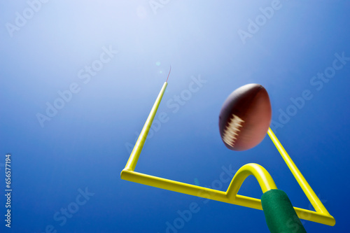 Field Goal or Extra Point in American Football looking up at the goal post as the ball flies through the air
