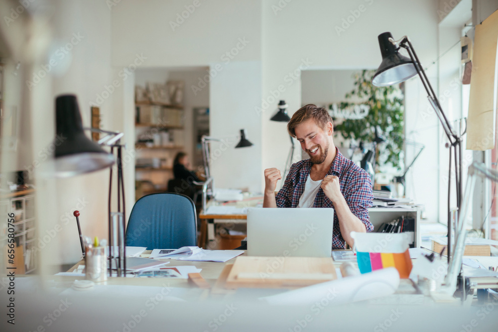 Young Caucasian male architect using the laptop and working on design in a startup company office Young Caucasian male architect using the laptop and working on design in a startup company office