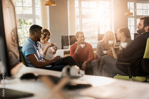 Young and diverse group of colleagues having a coffee break together in the computer office