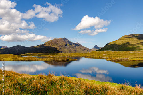 Beautiful Scottish landscape with reflection of clouds, lakes and mountains. Amazing wild nature on a sunny day. Shot taken on a trip around North Coast 500 photo