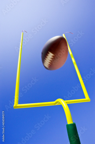 Field Goal or Extra Point in American Football looking up at the goal post as the ball flies through the air
