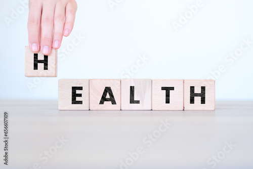 Man hand ordering Health letters on block cubes, medical or disease concept, wooden block cubes with Health word on it, wood blocks on white background, banner idea