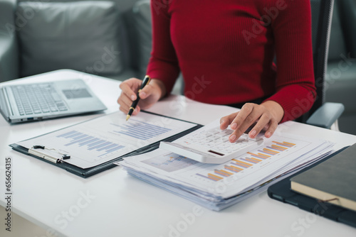 Businessman using a calculator to calculate numbers on a company s financial documents  he is analyzing historical financial data to plan how to grow the company. Financial concept.