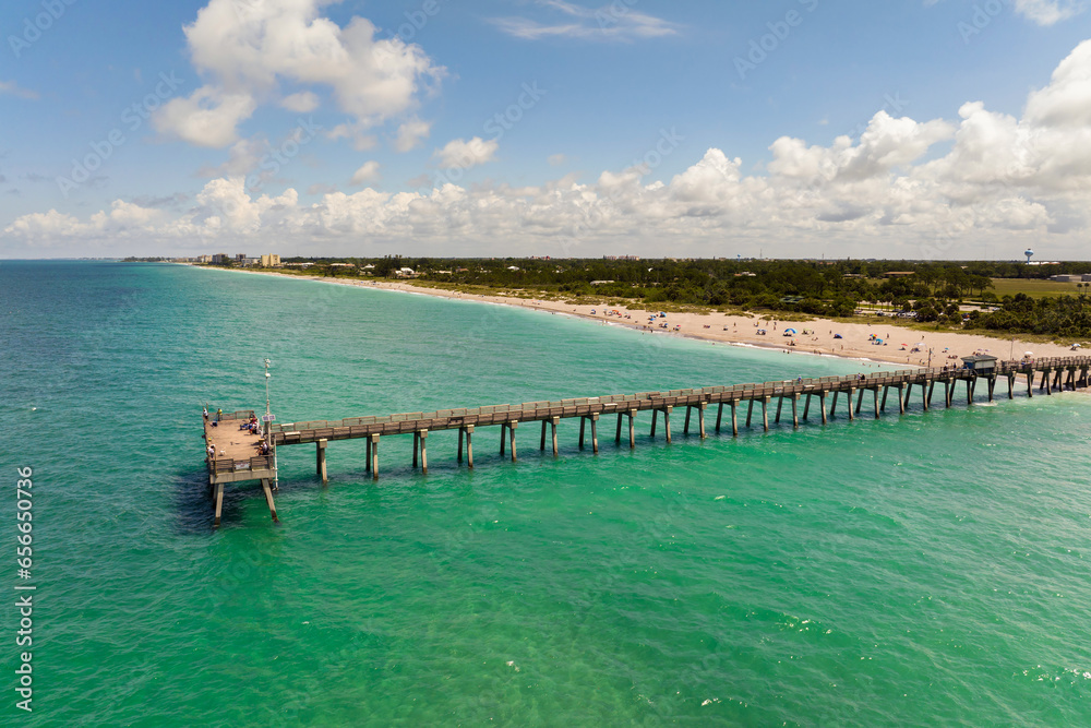 Venice fishing pier in Florida on sunny summer day. Bright seascape with surf waves crashing on sandy beach - obrazy, fototapety, plakaty 