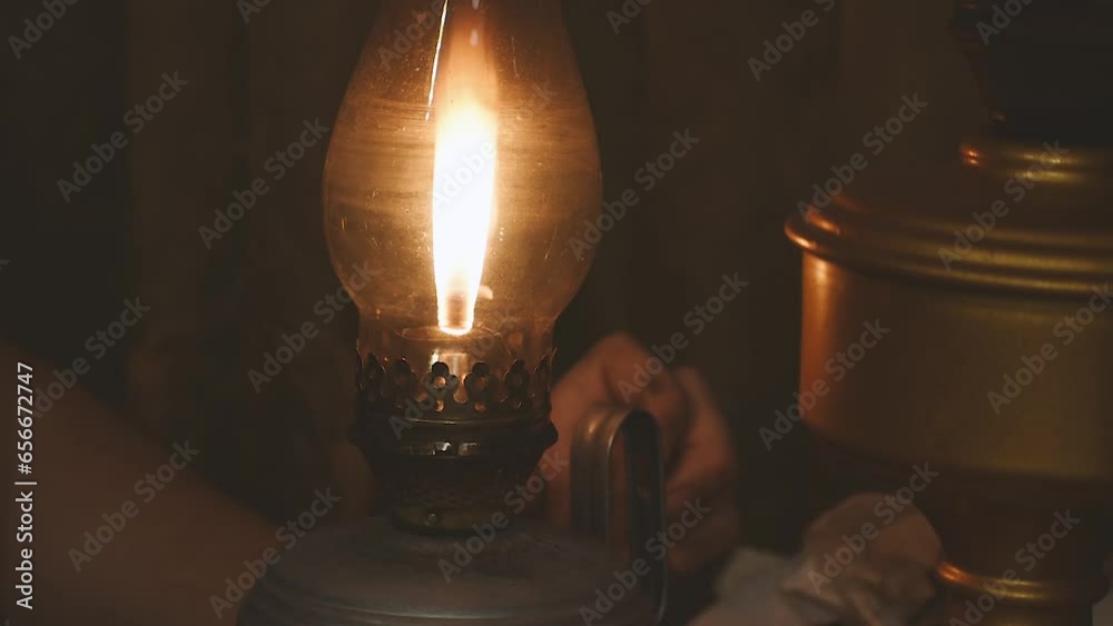 a boy lights an old kerosene lamp