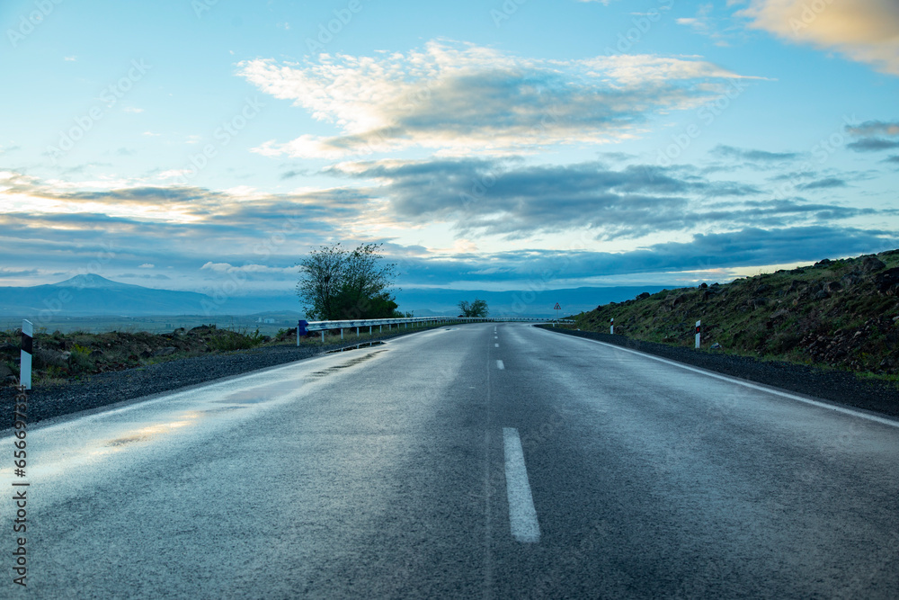 Naklejka premium empty asphalt road through the countryside of iceland at sunset