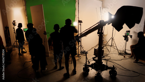 Silhouette images of making of or behind the scenes of video production which produced in the film studio that include all pro light and camera equipment and professional film crew with movie director photo
