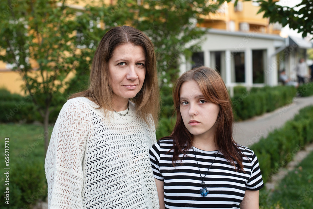 Obraz premium A woman with teenage daughter after a long conversation, clarifying the relationship, sad, thinking about how to live on, problems in relationship between children and parents