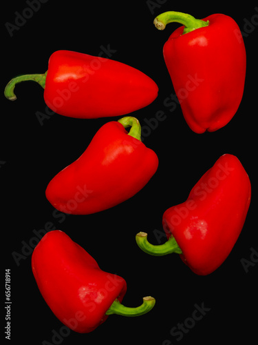 Red pepper. Several ripe red bell peppers on a black background, vegetables, sweet pepper
