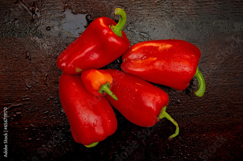 Red ripe bell pepper with dew drops on a wooden background, ripe pepper, vegetables