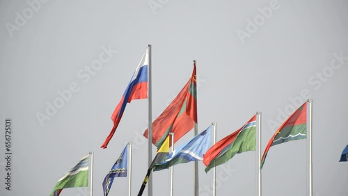 national flag of Transnistria and Russia against the sky. Below are the flags of cities and regions of Transnistria. Independence Day celebration. flagpoles on the central square of the capital photo