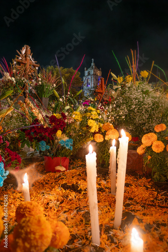 Mexico, San Andrés Míxquic-november 02 2019: Day of the Dead in a traditional mexican cementery, background of church, decorative graves, objects, flowers like cempasuchil and candles.					 photo