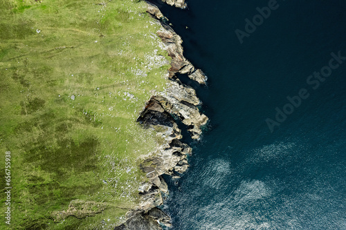 Top down view on rough coast line with green fields and cliffs by the ocean. Nobody. West of Ireland. photo