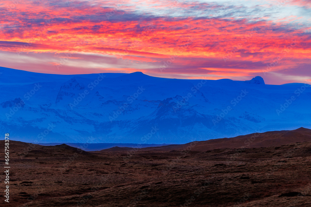 Icelandic chilly highlands with stunning sunset, concept for night photography. Breathtaking view of rosy cotton candy like sky due to sun setting above grand nordic mountain ranges.