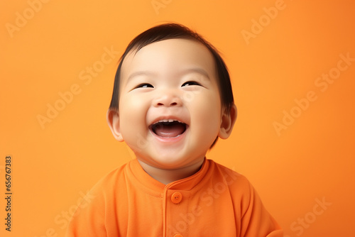 Portrait of happy asian baby in color clothing on color background