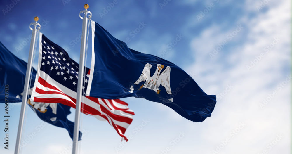 Louisiana state flag waving in the wind with the national flag of the United States - obrazy, fototapety, plakaty 