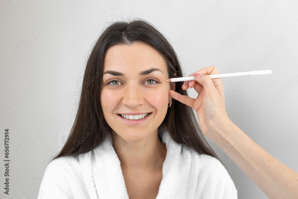 Beautician mark with white pencil the problem zone of woman's face skin Beautician mark with white pencil the problem zone of woman's face skin