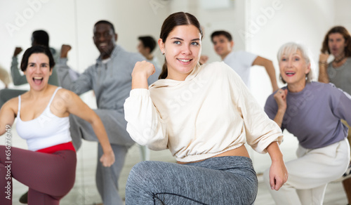 Active people of different nationalities learn sports dancing at a group class in a dance studio